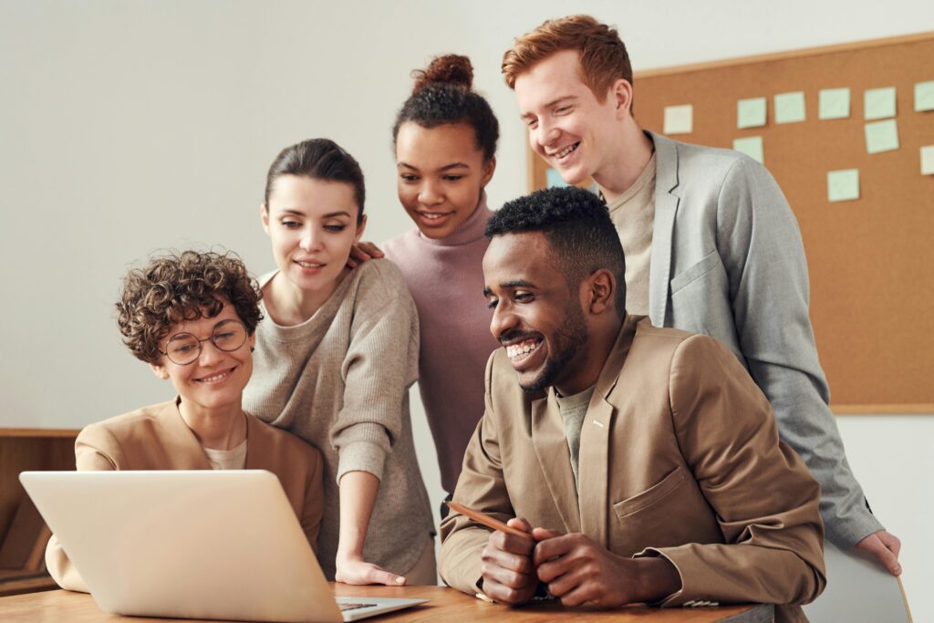 pexels photo 3182812 3182812 A group of diverse young professionals happily collaborating around a laptop indoors.