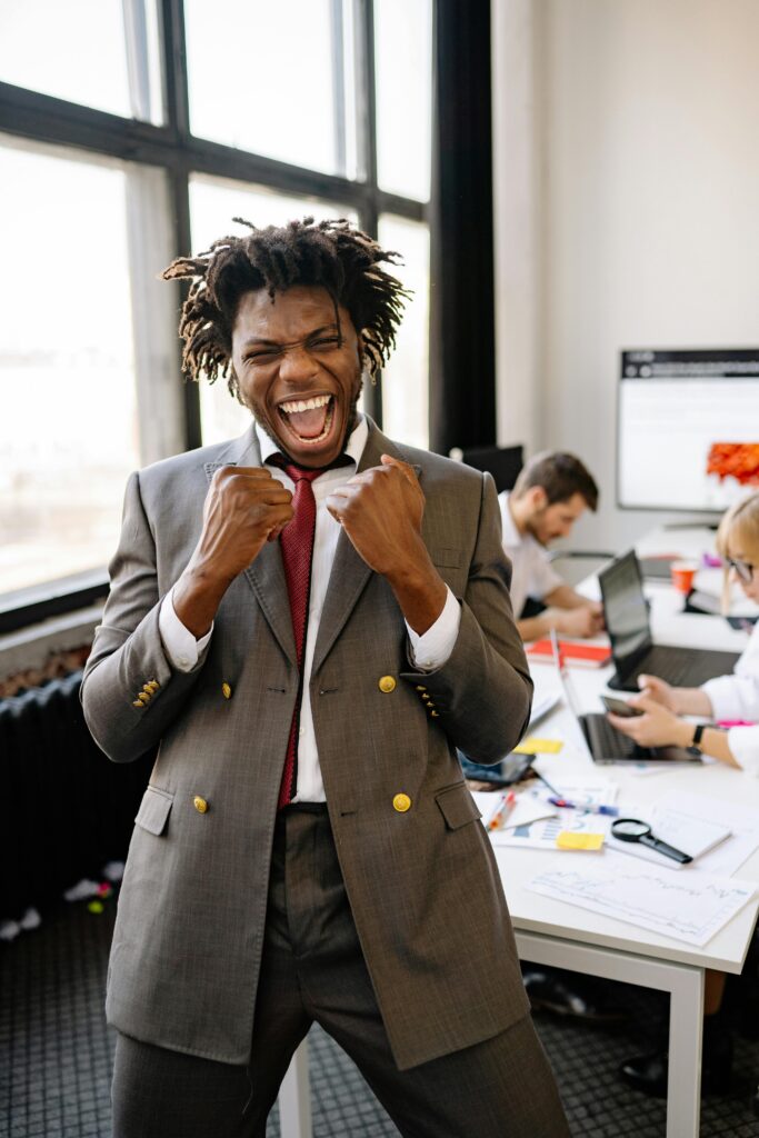 pexels photo 7793634 7793634 Excited African American businessman celebrating success with joy in an office setting.